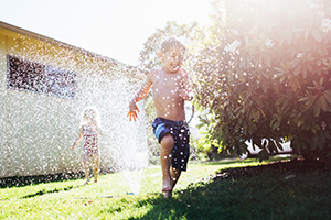 Children playing under a sprinkler